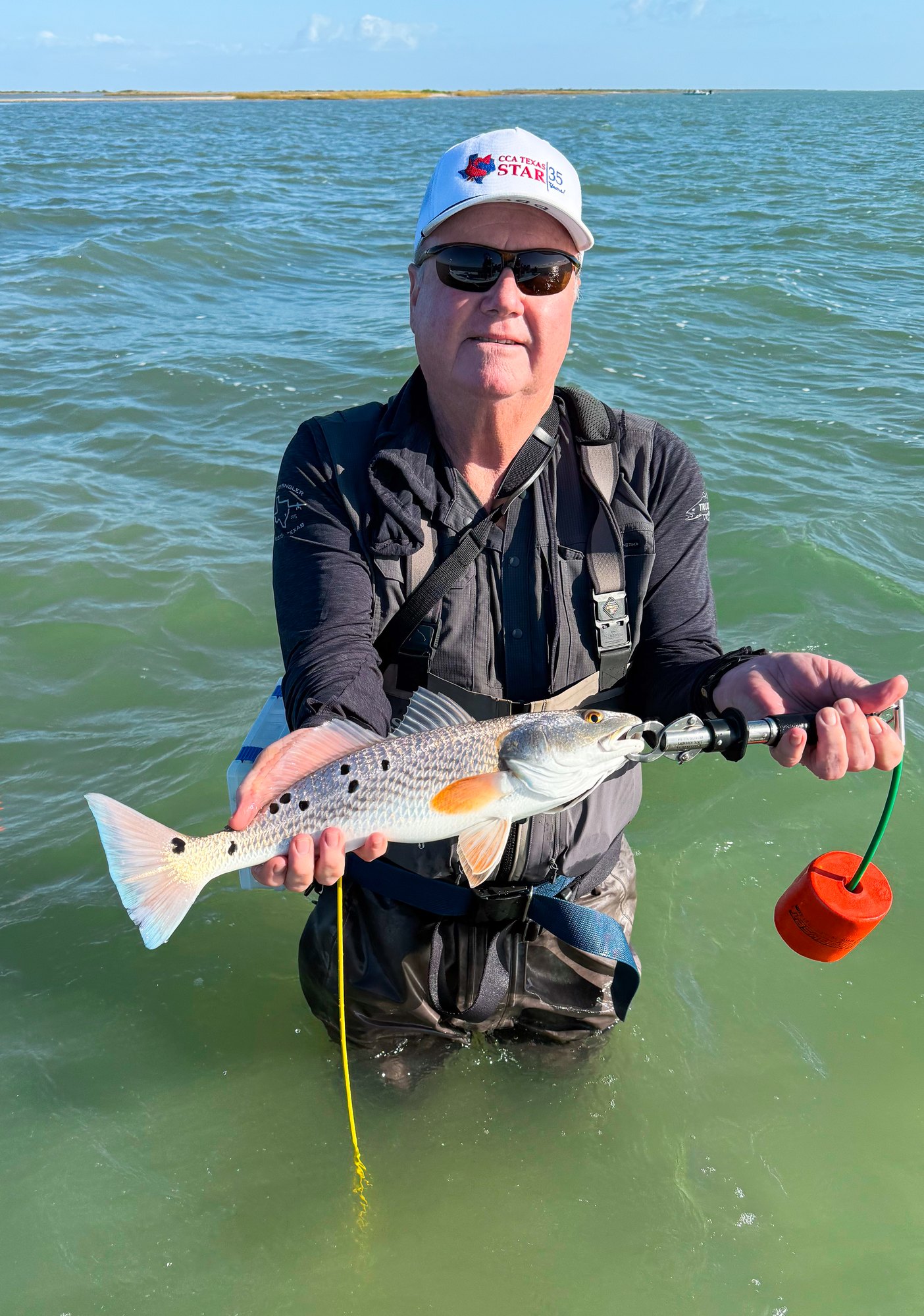Angler holding a spotted redfish in Port O'Connor