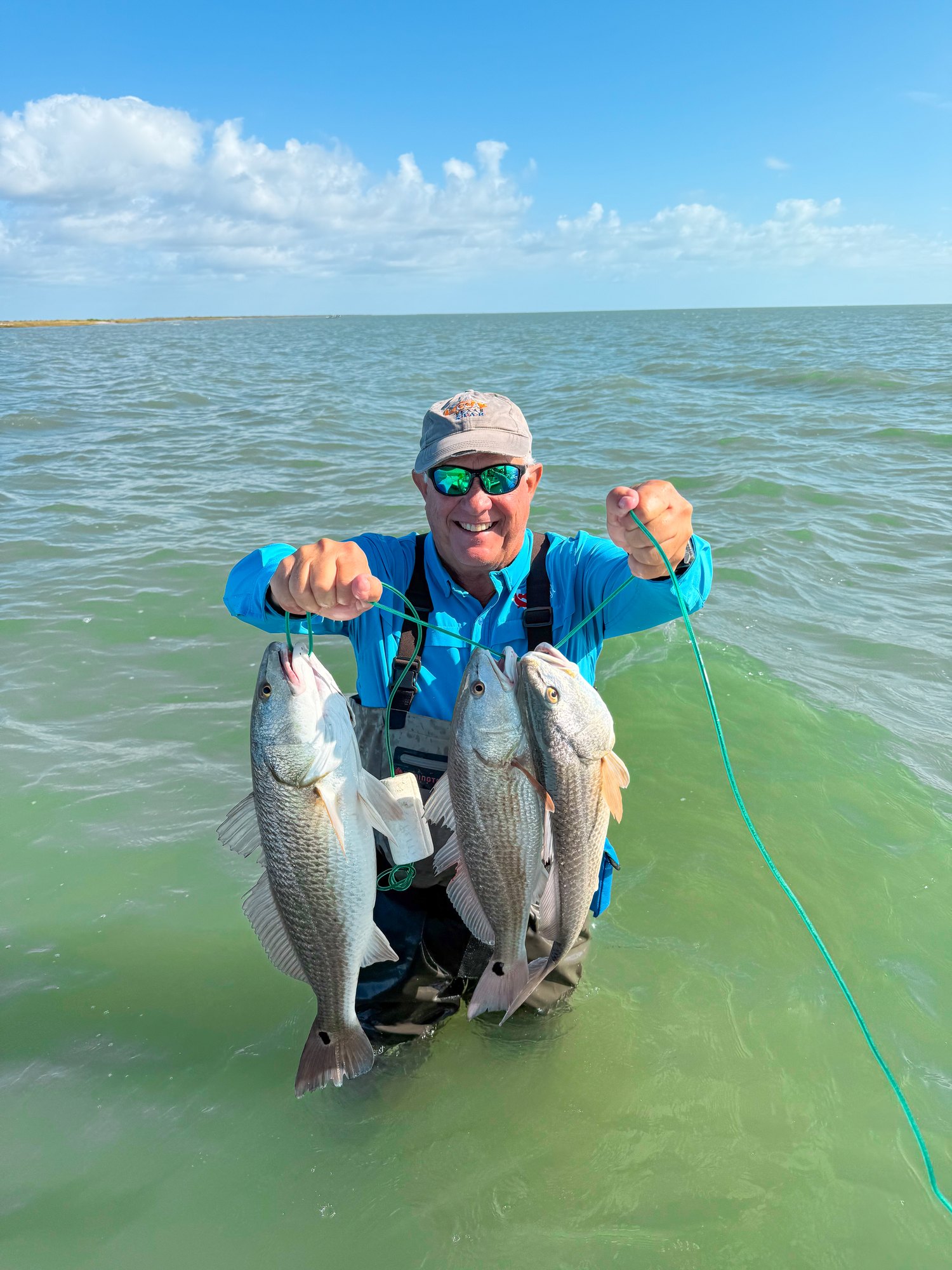Angler holding two redfish during a Port O'Connor bay trip